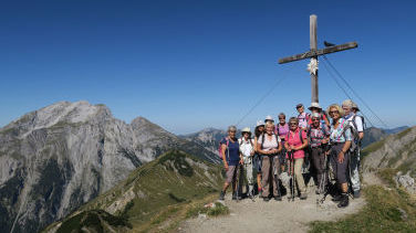 Eine sportliche und zufriedene Gruppe am Gipfel