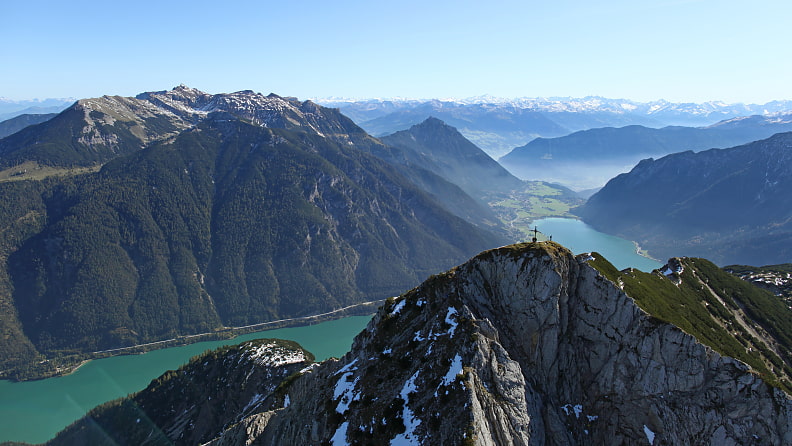 Das Gipfelkreuz der Seebergspitze, dahinter der türkisblaue Achensee. 