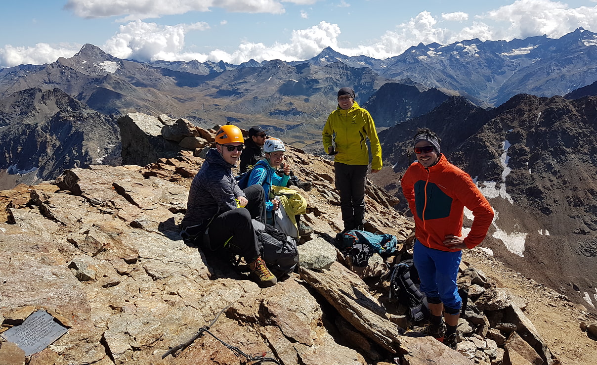 Zur Gipfelbrotzeit versammelt: Trotz unterschiedlicher Aufstiegsrouten sitzen wir gemeinsam auf 3559 Metern.