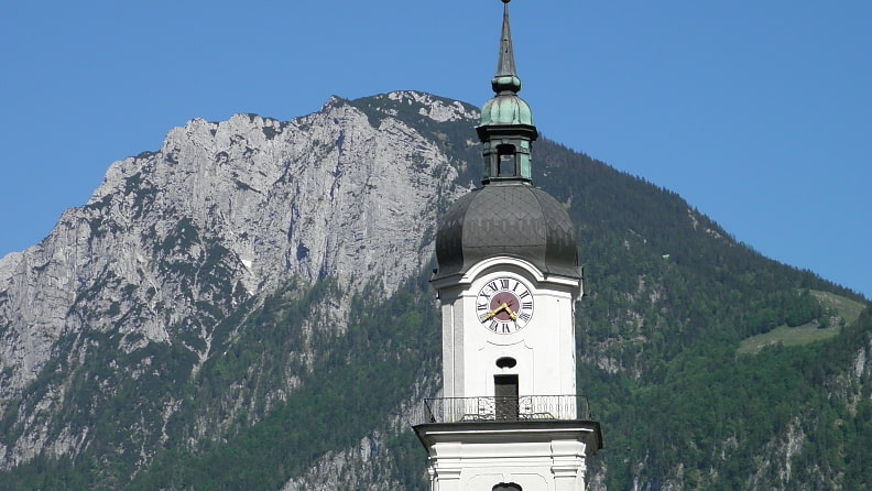 Die Pfarrkirche Heilig Kreuz, dahinter der Zahme Kaiser