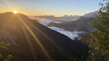 Ein wunderschöner Sonnenaufgang strahlt über das unter uns liegende Wolkenmeer.