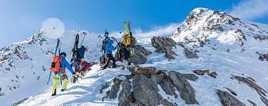 Vier Skibergsteiger auf einem Bergrücken