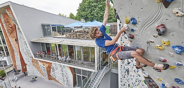 Kletterer an Außenwand einer Kletteranlage 
