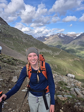 Leiterin Priska steht lächelnd auf einem schönem Wanderweg