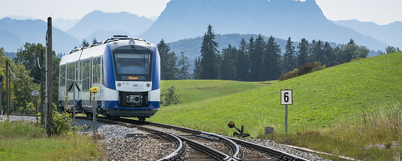 Bild zeigt den BOB Abkürzung für Bayerische Oberland Bahn von vorne wie er zu einer Gleiszweigung kommt im Voralpenland 