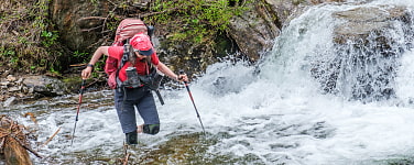 Frau stapft durch wadenhohen Fluss