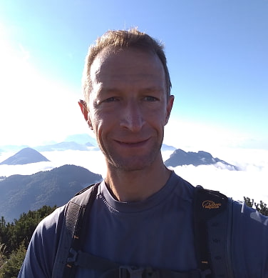 Bergwanderer über Wolken und Berggipfeln im Hintergrund