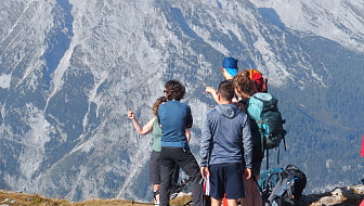 Eine Gruppe Tourteilnehmender steht auf einem Gipfel im Nationalpark Berchtesgaden.
