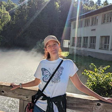 Sandra Stauche auf einer Holzbrücke. Hinter ihr ein Gewässer, über dem Dunst schwebt.