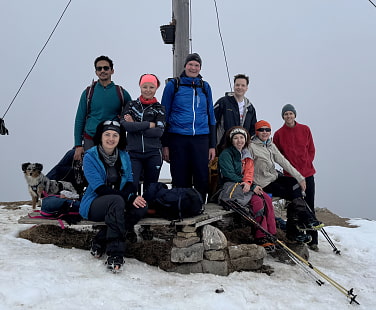 Die Gruppe auf dem verschneiten Gipfel des Hirschberg am Tegernsee.