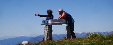 zwei Tourenbegleiter am Gipfel orten die umliegenden Berge