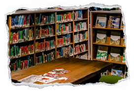 Bild zeigt einen Ausschnitt der Bibliothek der Sektion mit vielen Büchern in den Regalen und einem Tisch im Vordergrund