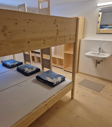 Holzstockbetten im Mehrbettzimmer mit Waschbecken