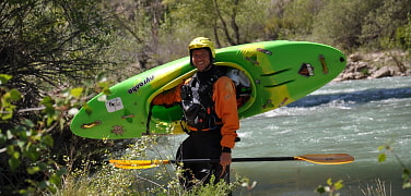Ein glücklicher Paddler, der sein Boot rausträgt.