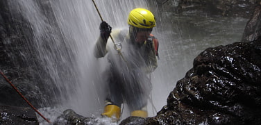 Ein Canyoning-Teilnehmer im Wasserfall
