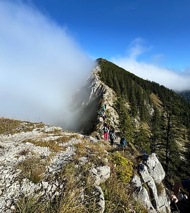 A group is hiking a mountain ridge