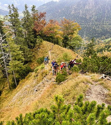 A group is hiking a green mountain ridge