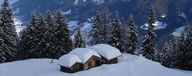 Tiefverschneite Almhütten