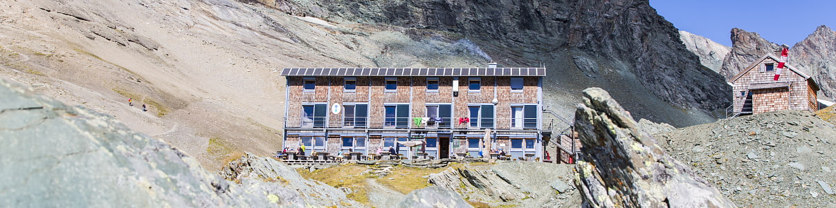 Drei Wandernde auf dem Weg zur Hütte 