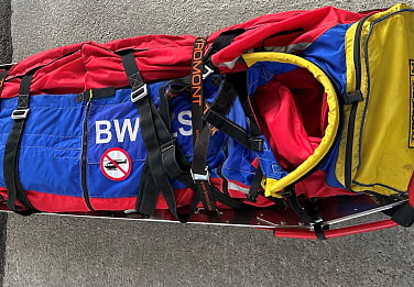 Bergwachtkler schneide verletzte Person an Kletterwand aus Seil.