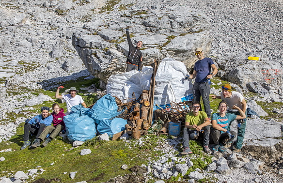 Acht Jugendliche vor großen Müllsäcke und Altmetall auf dem zugspitzplatt.