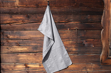 graues Funktionshandtuch vor Hüttenwand