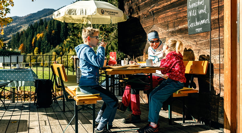 Familie im Herbst auf der Sonnenterasse der Oberlandhütte 