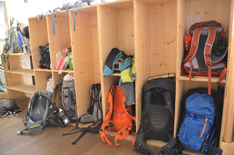 Rücksacke stehen in Fächern von einem Holzschrank