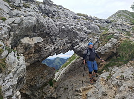 Ein Wanderer vor einem Felsenfenster