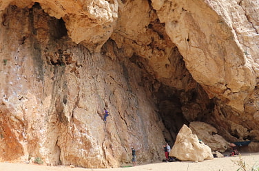 Kletternde Personen an rotbrauner Felswand mit grossem Überhang